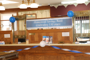 A indoor banner reading "Homestead Savings Bank Celebrating 130 years!"