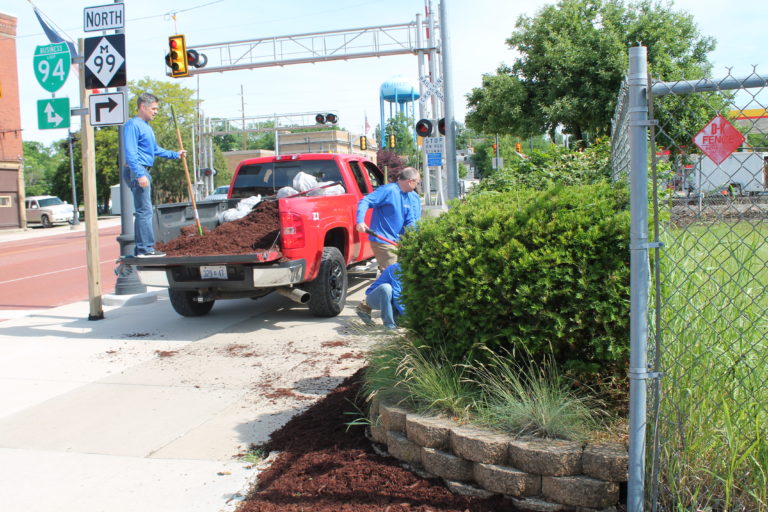The Homestead team replacing mulch for a tree in downtown Albion.